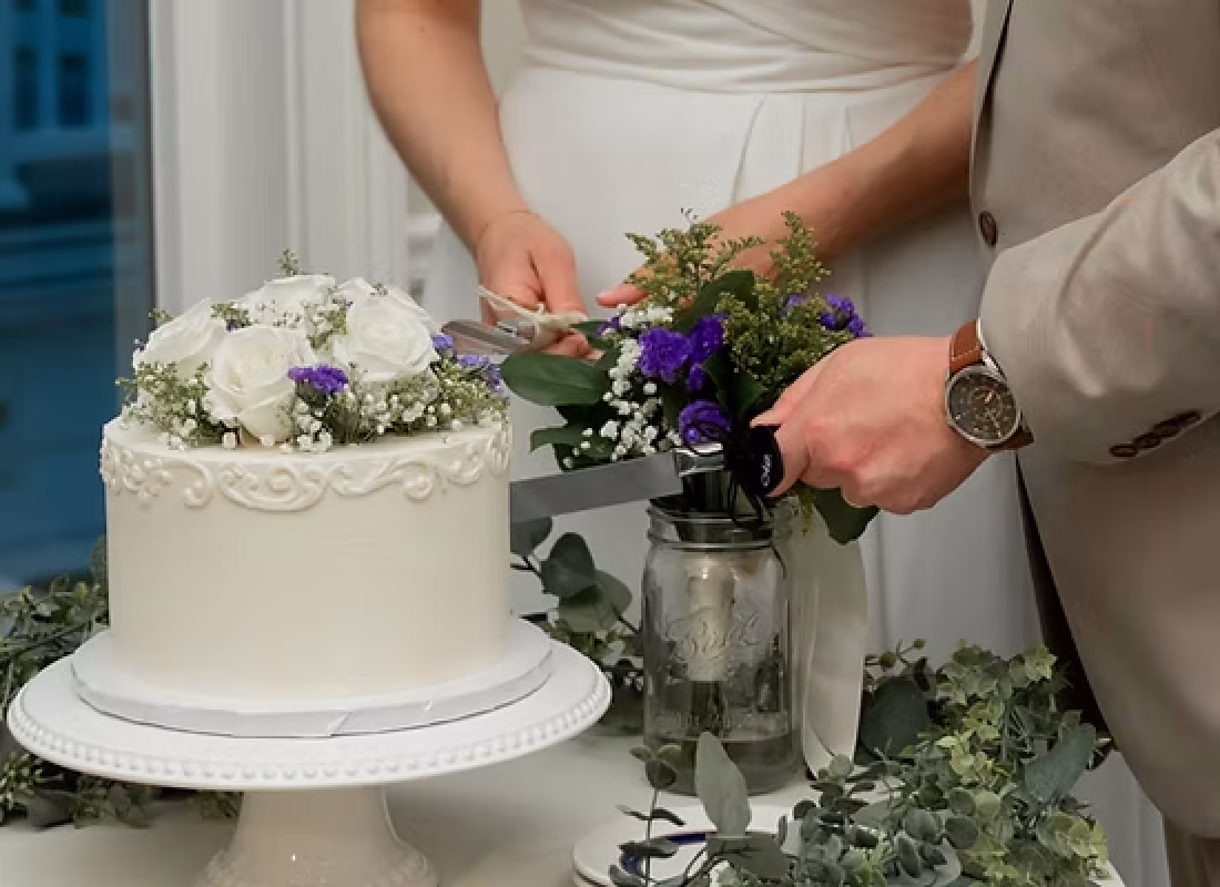 Cake designer applying gold leaf detail to an elegant wedding cake in a The Woodlands, TX banquet hall