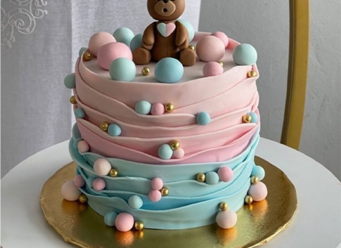 Pastry artist assembling a multi-tiered cake with climate-stable ingredients for a Houston summer wedding