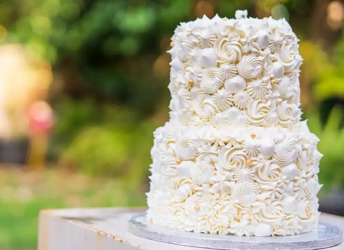 Bakery artist decorating a custom wedding cake for a Houston reception