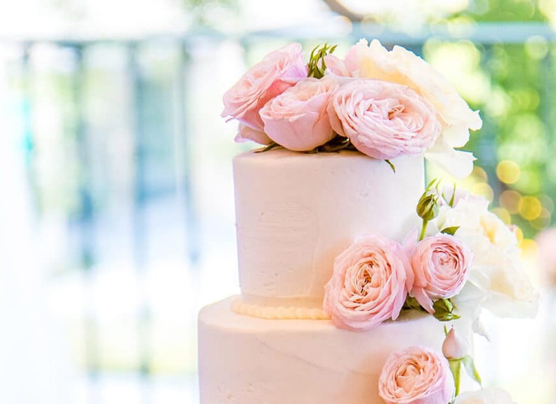 Experienced decorator carefully piping sugar lace onto a wedding cake in a Deer Park, TX bakery